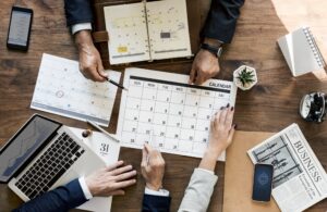 Group Of Business People Having A Meeting With a Calendar