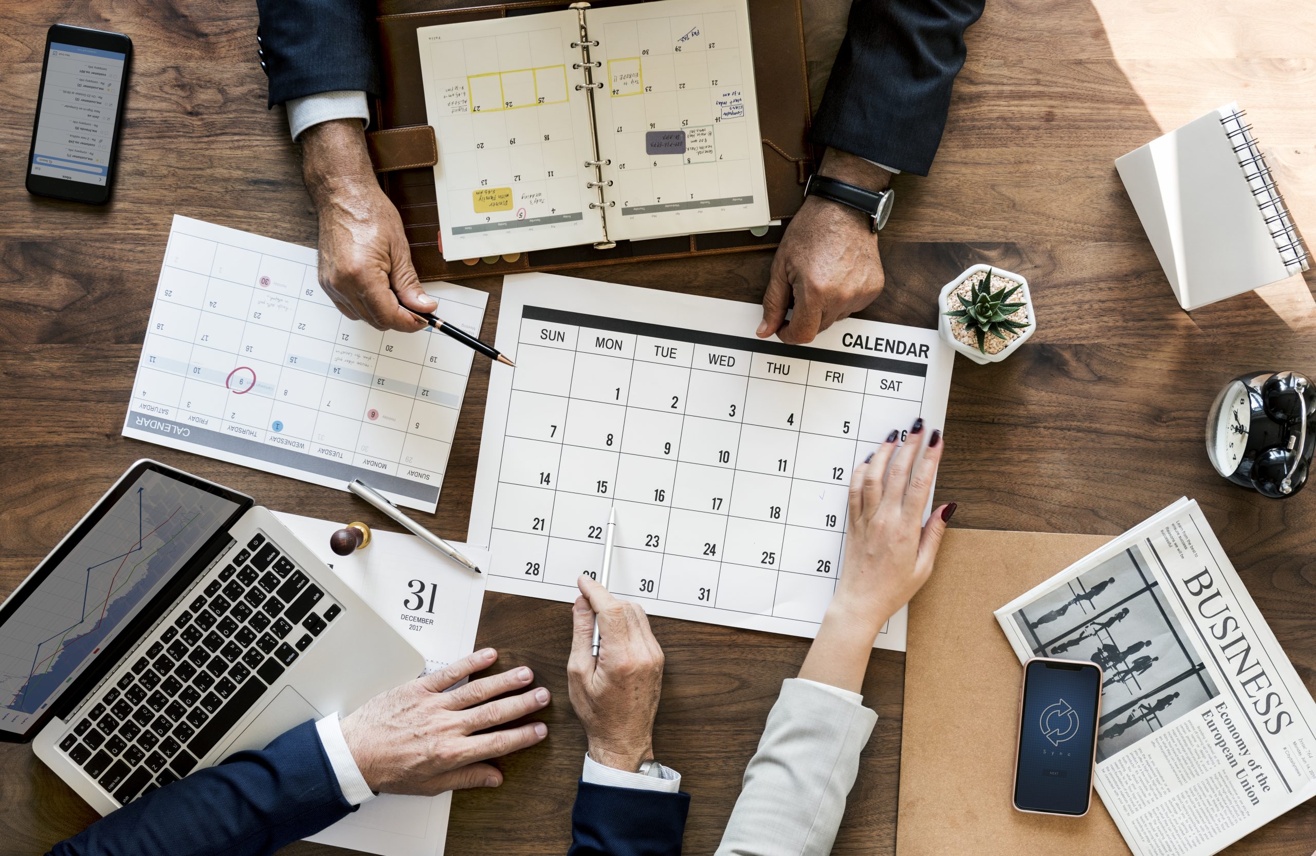 Group Of Business People Having A Meeting With a Calendar
