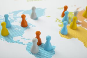 High Angle of Colorful Pawns across a map showing continents